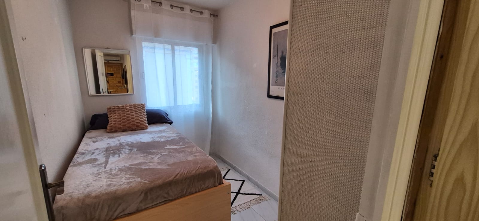 Second bedroom with bed, mirror and window