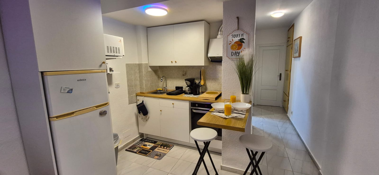 Fitted kitchen with oven, fridge and breakfast bar