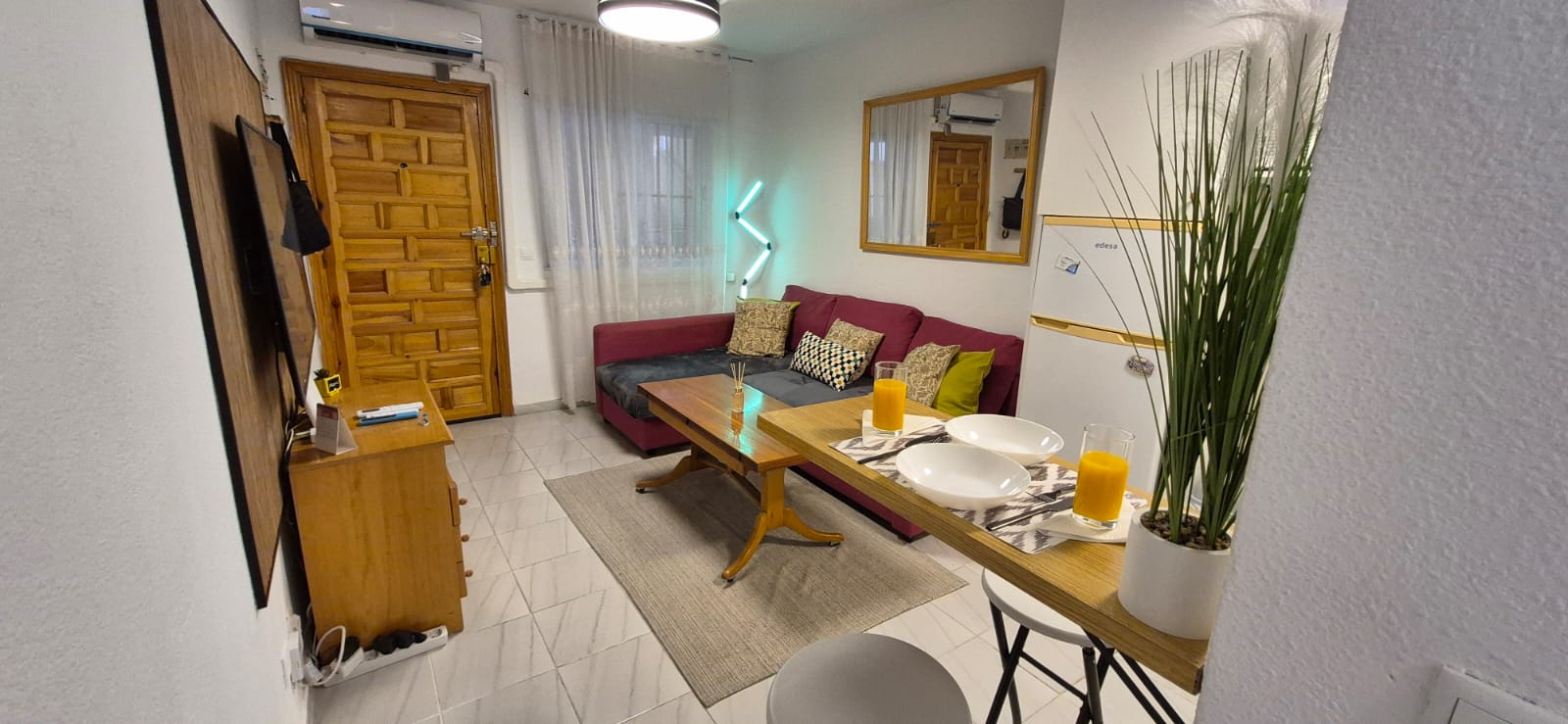 Living room with sofa and traditional Spanish carved wooden entrance door