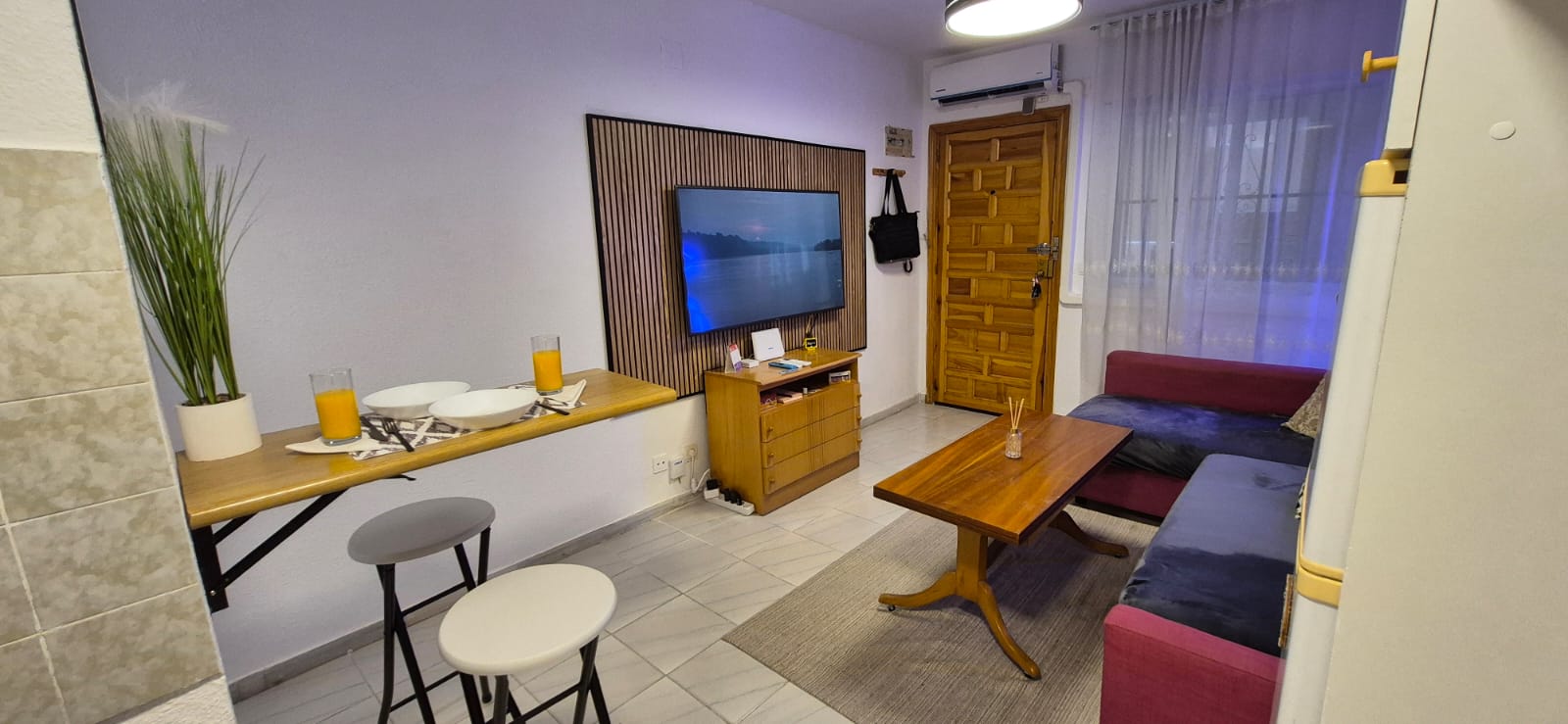 TV corner with wood slat panel and dining bar